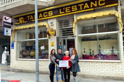 Els responsables i treballadors de l'estanc d'Amposta amb el cartell que anuncia el premi d'1 MEUR que han repartit.