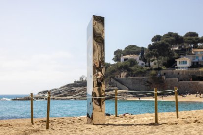 Playa de Sa Conca con el monolito de acero inoxidable en el medio.