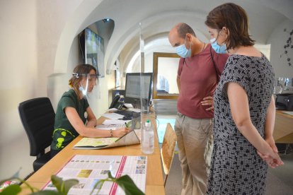 Dues persones demanen informació a l'Oficina de Turisme d'Olot.