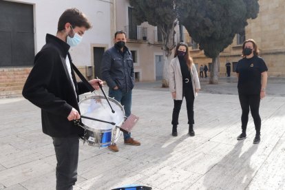 Un miembro de la banda|lado del paso La Flagel·lació de la Real y Venerable Congregación de la Puríssima Sang tocando el timbal y de representantes de otras cofradías de Tarragona.