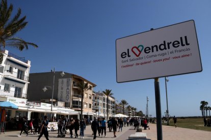 Personas andando|caminando por el paseo marítimo de Coma-ruga, al Vendrell, este Viernes Santo.