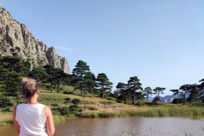 Plano medio de una chica contemplando la  Bassa de la Refoia en el Parc Natural dels Ports.