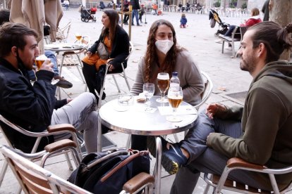 Unos jóvenes toman una cerveza en una terraza en la plaza de la Virreina.