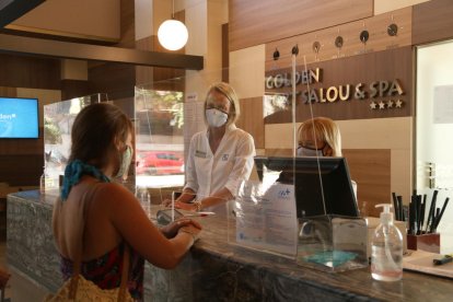 Una turista y dos trabajadoras en la recepción de un hotel de Salou.