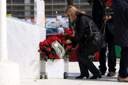 Una afectada per la tragèdia de Germanwings deixant una rosa al monument de la T2 del Prat, durant l'acte d'homenatge a les víctimes en el segon aniversari del succés.