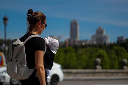 Una mujer pasea con su hijo por Madrid.