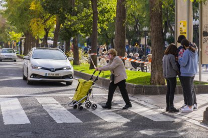 Imatge d'una dona gran creuant un pas de vianants a la Rambla Nova de Tarragona.