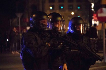 Tres antidisturbios de los Mossos con pistolas de foam en el centro de Barcelona.