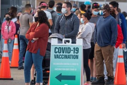 Un grup de persones fent cua a un centre de vacunació als Estats Units.