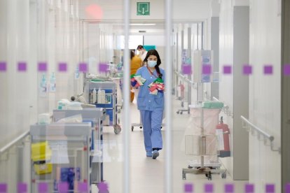 Vista de una profesional sanitaria a través de unas puertas del nuevo espacio polivalente del Hospital de Bellvitge