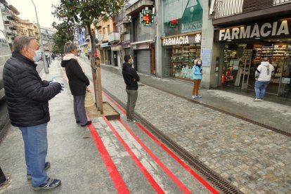 Gente haciendo cola en una farmacia.