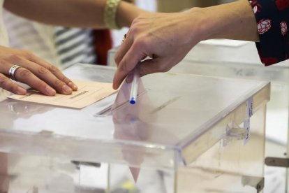 Imagen de archivo de una persona depositando su voto en una urna.