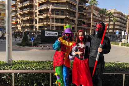 Ciudadanos de Salou disfrazados con la pancarta «Tornarem» de fondo.