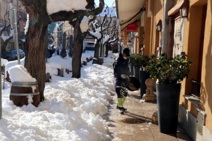 Plan|Plano abierto de un efectivo de la brigada muniicpal de Falset esparciendo sal en una céntrica calle de la capital del Priorat