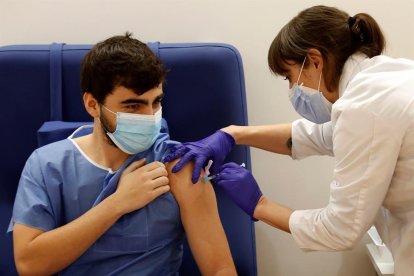 Una infermera de l'Hospital Clinic de Barcelona administra la vacuna Pfizer BioNTech a un sanitari aquest diumenge.