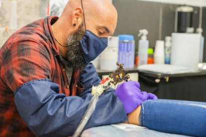 Carlos Latorre, del estudio Chopper Ink Tattoo, tatuando el tobillo de una chica en su local del Cós del Bou la semana pasada.