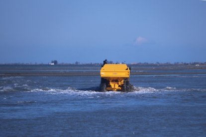 Plano general de un camión avanzando por una zona inundada de la barra del Trabucador.