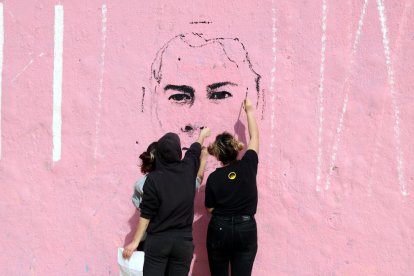 Tres artistes realitzen una pintura mural amb un retrat de Pablo Hasél als Jardins de les Tres Xemeneies.