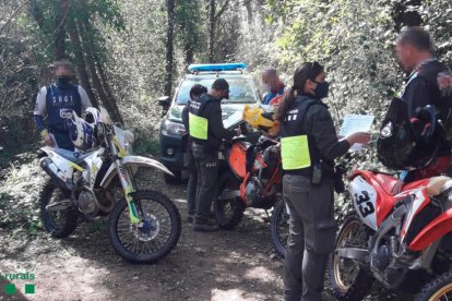 Unos Agentes Rurales multando a unos motoristas en Riudaura.