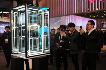 Diverses persones fan fotografies al nou mòbil de Samsung, al Mobile World Congress, el 25 de febrer