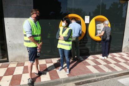 Imagen de Trinitat con una voluntaria en el cajero automático de la Caja a Sant Pere i Sant Pau.