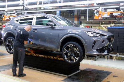 Un operari treballant en un Cupra Formentor a la cadena de producció.