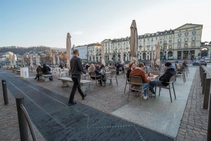 Desenes de persones a la terrassa d'una cafeteria a Turín.