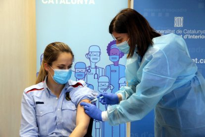 Pla obert d'una infermera administrant la primera dosi de la vacuna d'AstraZeneca a una policia a la comissaria de Campclar dels Mossos d'Esquadra.