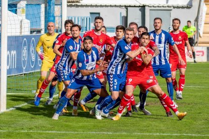 Los jugadores del Nàstic y el Alcoyano pugnando a la salida de un córner.