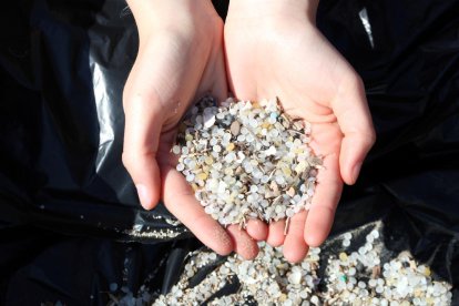 Plano detalle de las microesferas de polietileno y de poliestireno a manos de una de las voluntarias de Greenpeace en la jornada de limpieza en la Playa de La Pineda de Vila-seca.