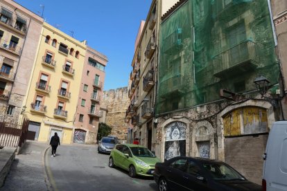 Una red cubre el edificio del número 21 de la Baixada de la Peixateria, tapiado desde hace años.