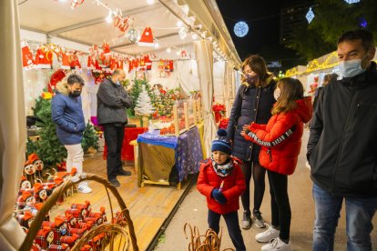 Imatge de diversos clients passejant pel tram de la Rambla on s'ha col·locat la Fira de Nadal.