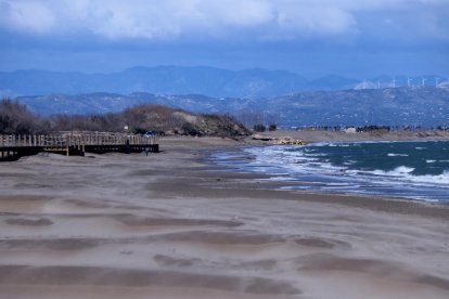 Tram nord de la platja de Riumar, amb l'aigua del mar apropant-se a les passarel·les de fusta.