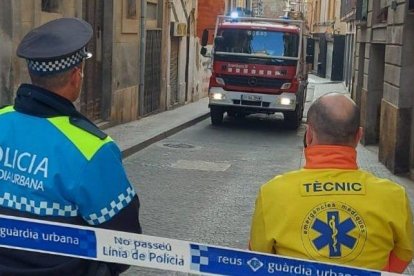 Un miembro de la Guàrdia Urbana y del SEM observando el camión de bomberos.