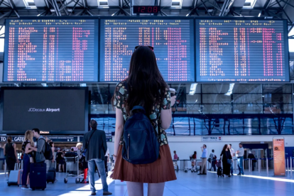 Una noia espera el seu vol en un aeroport.