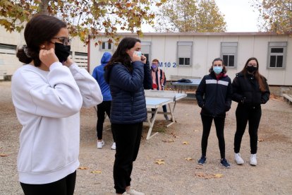 Dues alumnes de l'Institut d'Alcanar explicant els bons usos de la mascareta als seus companys.