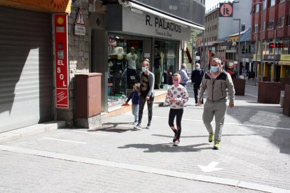 Un grup de persones passejant per un dels carrers comercials del Pas de la Casa.