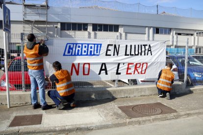 Los trabajadores colgando una pancarta en Vic.