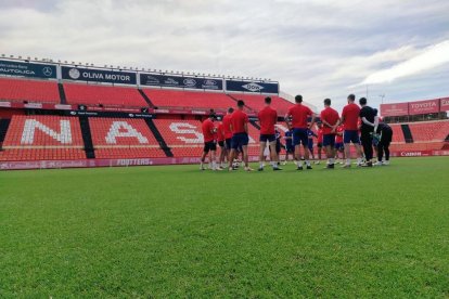 Los jugadores de l'Olot en el césped del Nou Estadi.