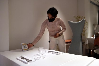 Una trabajadora de uno de los restaurantes de Cambrils preparando las mesas antes del servicio.