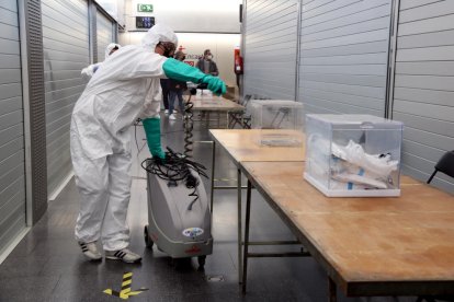 Un equipo de desinfección fumiga las urnas i las mesas del Mercat de Sant Antoni.