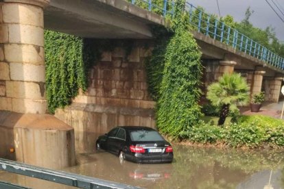 Un vehículo que ha quedado bajo el agua en la riera de Alforja de Cambrils.