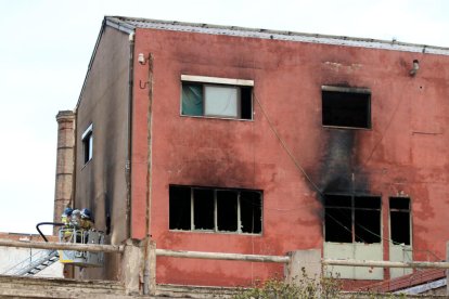 Bombers treballen en l'incendi de la nau industrial abandonada i ocupada a Badalona.