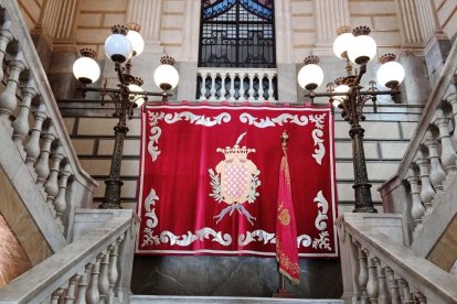 El domàs i la bandera de la ciutat presideixen les escales principals de l'Ajuntament de Tarragona.