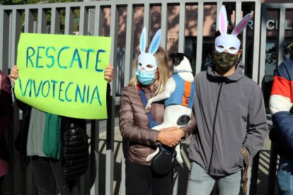 Imatge de dos dels participants al costat d'un pancarta reclamant el rescat dels animals de Vivotecnia.