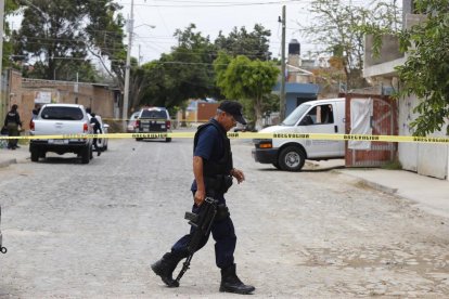 Un policía municipal camina hoy por el área acordonada de una fosa clandestina e