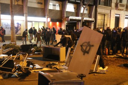 Manifestants formen una barricada al costat d'una sucursal bancària, a Barcelona.