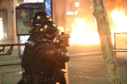 Un agente de los Mossos d'Esquadra dispara una bala de foam en el marco de los disturbios por el encarcelamiento del cantante Pablo Hasel en Barcelona.