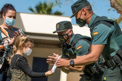 Los agentes de la Guardia Civil entregan un diploma a la pequeña.