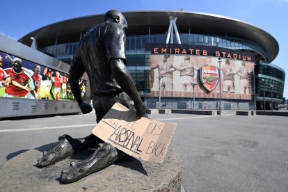 Un cartell amb el missatge 'Torneu-nos al nostre Arsenal' col·locat a les portes del Emirates Stadium del club.